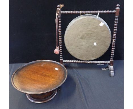 A DINNER GONG ON BOBBIN-TURNED STAND 46cm wide, and a mahogany lazy Susan 38cm dia (2)
