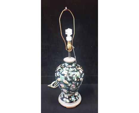 A CHINESE PORCELAIN BALUSTER TABLE LAMP enamelled insects and flowers on a black ground 44cm high plus fitting