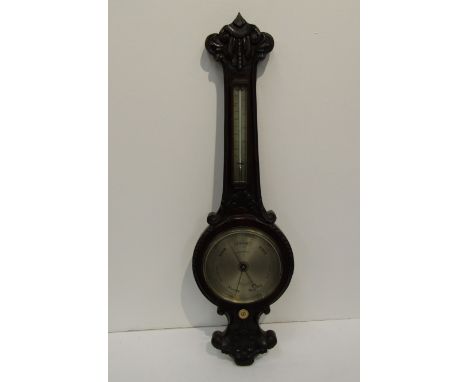 A 19th Century carved and stained oak aneroid barometer/ thermometer, with silvered scale plates, named "Gardner &amp; Co, Gl