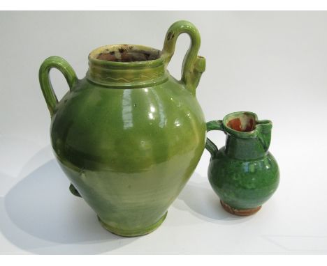 A large green glazed earthenware wine/ olive oil jar. 42cm tall. A green glazed earthenware jug. 21.5cm tall (2)