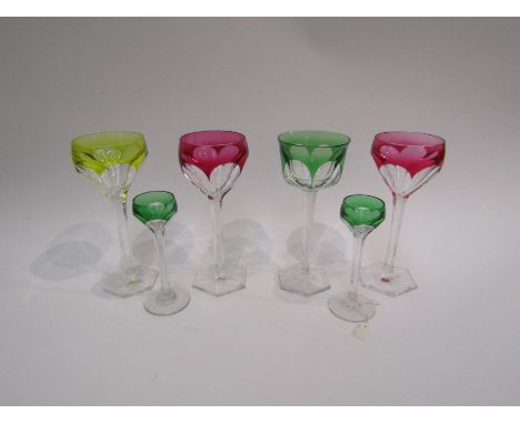 A pair of St. Louis liqueur glasses with green overlay, panel-cut crocus-shaped bowls and paneled stems. A similar pair of cr