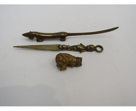 A late Victorian hollow cast brass paperknife handle as the head of a dog wearing a collar inscribed "Tom" (blade missing).  