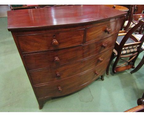 A circa 1830 flame mahogany bow front chest of two short over three graduating long drawers with turned bun handles and oak l