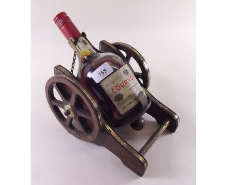 A Courvoisier vintage bottle of cognac on gun carriage stand, unopened