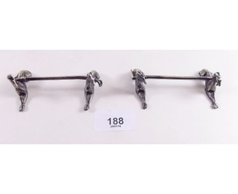A pair of 'hunting' silver plated knife rests in the form of whippets supporting riding crops