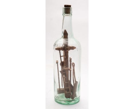 A late 19th early century set of miniature Shipwright's tools in bottle. 30cm high