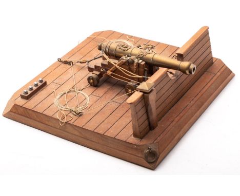A scale model of a ship's gun, the five stage brass barrel with lion mask applique on a wooden truck with brass wheels  set  