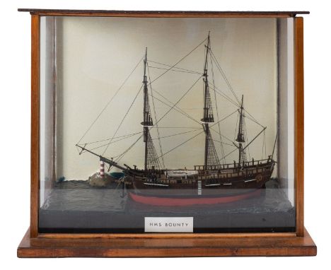 A cased waterline model of HMS 'Bounty', standing and running rigged over deck with figures and fittings, the hull painted br