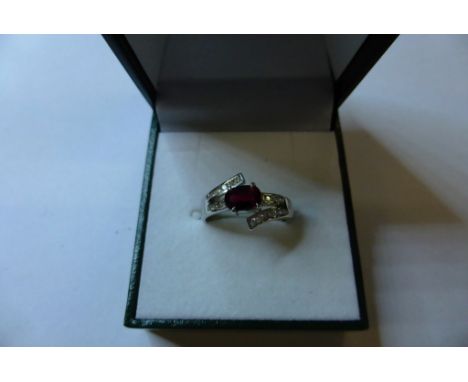 An 18ct white gold, ruby and diamond cross over ring (size L)