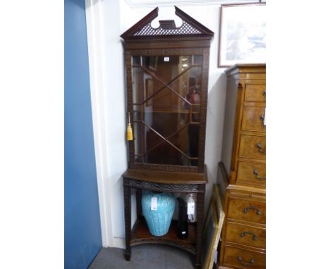 A Chippendale style blind feet carved and glazed mahogany display cabinet on stand,c.1910, the broken arch fretwork top over 