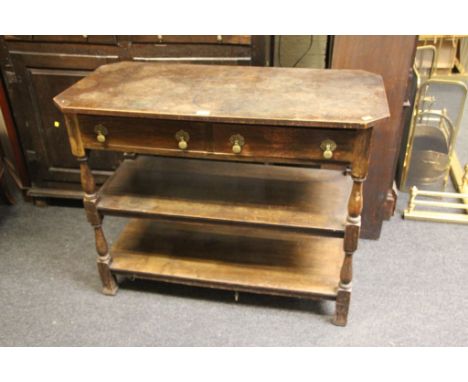 An early 20th century oak buffet, having rectangular top with canted corners over two frieze drawers and two open shelves on 