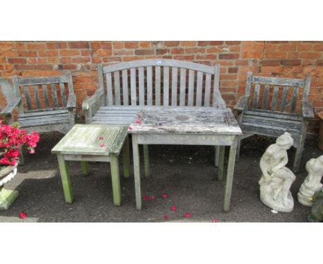 A five piece teak garden suite, comprising two person bench, a pair of armchairs and two tables