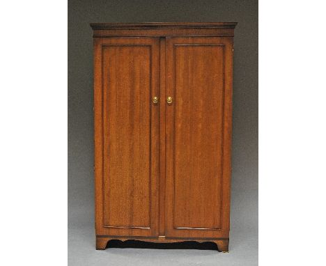 A mahogany wardrobe, 20th century, two paneled doors raised on bracket feet, 178cm high x 107cm wide x 53cm deep. 