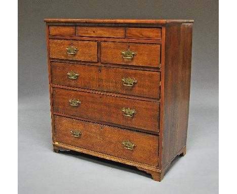 A George III oak chest of drawers, secret drawer over two short and three lomg drawers, raised on bracket feet, 107cm high x 