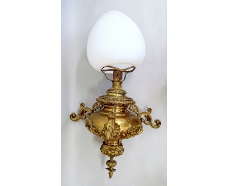 A large Victorian brass hanging oil lamp, the body of bulbous shape emitting three branches of scrolling and cherub head form
