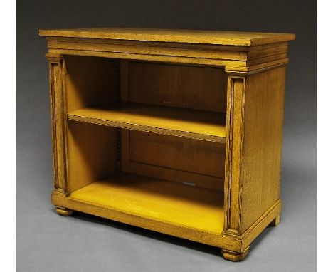 A Gothic style oak bookcase, 20th century, the rectangular top over single shelf, flanked by inset columns, raised on bun fee