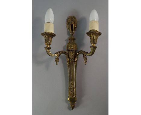 A gilt bronze twin branch wall light, 20th century, the back plate with fluted and hare bell moulded decoration, with scrolli