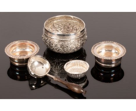 A Burmese white metal bowl, embossed throughout, a ladle with wooden handle and a bowl set with a coin, and two plated coaste