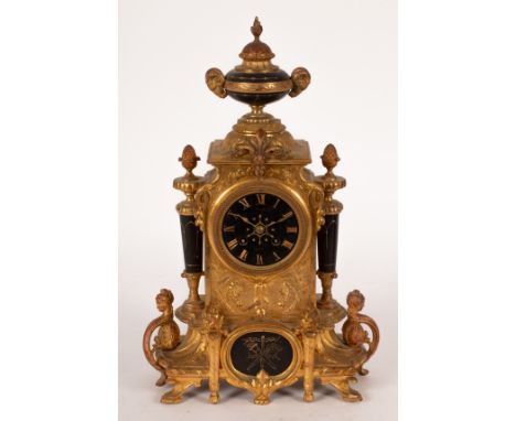 A 19th Century French gilt metal mantel clock with twin-train movement, the dial with Roman numerals, a central urn finial wi