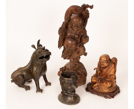 A Chinese bronze metal figure of a Kelvin, two Oriental carved figures and a mask head grotesque CONDITION REPORT: Condition 