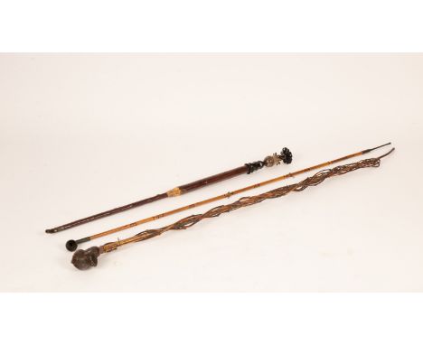 A collection of opium pipes and related paraphernalia, the largest with central bamboo stem entwined by vines, the pipe bowl 