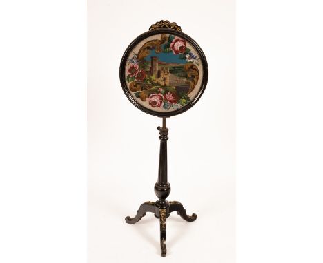 A pole screen with gilded ribbon tie surmount and circular beadwork panel of Caernarfon Castle, on a gilded tripod base, 131c