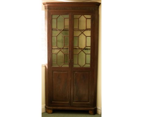 A George III two-tier mahogany corner cupboard enclosed by glazed bar doors and panel doors beneath, 115cm wide CONDITION REP