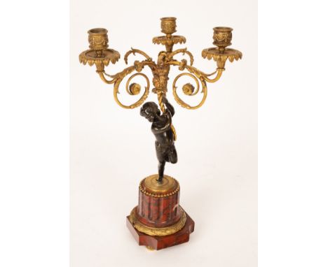 A three-light gilt metal table light with bronze putto support and marble base, 43cm high CONDITION REPORT: Condition informa