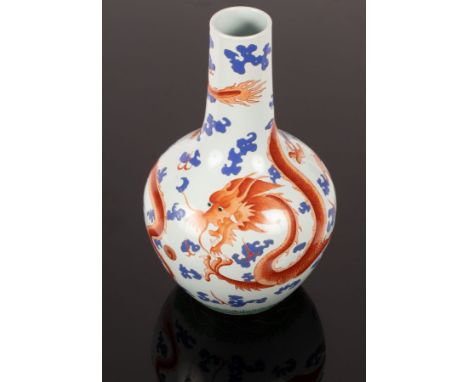 A Chinese porcelain vase, Tianqiuping, 20th Century, depicting red dragons flying among blue clouds on white ground, 39.5cm h