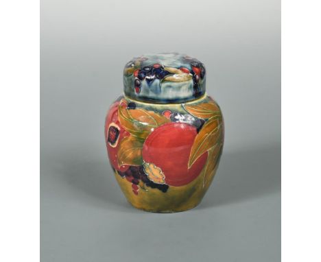 A small early Moorcroft Pomegranate pattern jar and cover, shape no. 769, painted with cut and full fruits to a mottled green