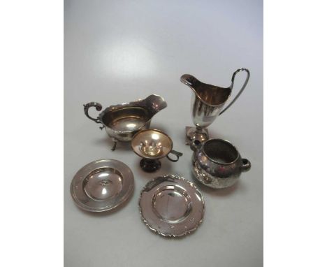 A silver helmet shaped cream jug together with a silver sauce boat, 2 silver pin trays, a silver chamberstick and a hammered 