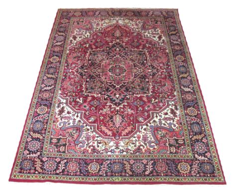 HERIZ CARPET, 272cm x 186cm, North West Persia, midnight blue medallion on a ruby field of stylised botanical motifs within c