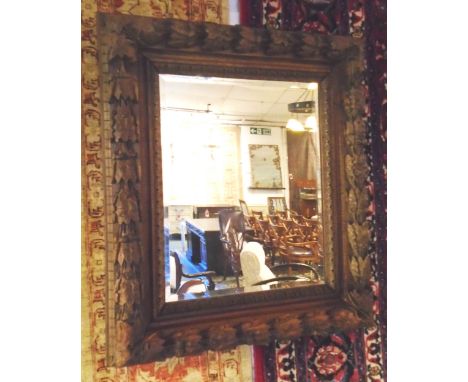 WALL MIRROR, 19th century Continental walnut rectangular with carved acorn and leaf decoration and a central bevelled plate, 