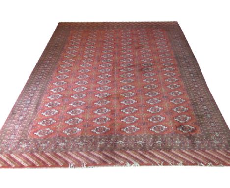 VINTAGE TEKKE CARPET, 400cm x 309cm, West Turkestan, repeat tribal gul design on a terracotta field, within multiple geometri