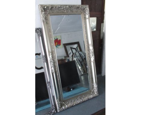 WALL MIRROR, rectangular with an elaborate silver gilt frame and bevelled plate, 91cm W x 183cm H. 