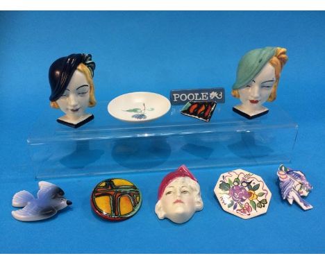 A Royal Doulton Art Deco mask, HN1612, five Poole pottery brooches, two Art Deco mask napkin ring holders etc. (10)