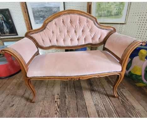 A vintage pink upholstered button back settee. 85cm x 110cm x 43cm.