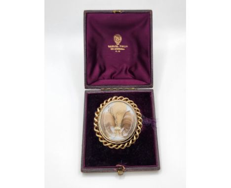 A Victorian Memento Mori hair braids in oval gold coloured mount with a twisted 12ct yellow gold surround and a portrait of a