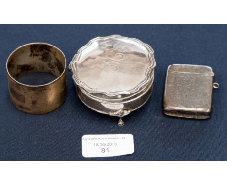 A silver three footed cushioned trinket pot and cover, with a silver napkin ring and a silver vesta 