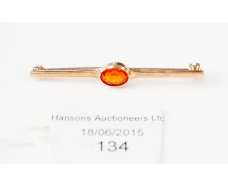 A 9ct gold bar brooch set with single oval fire opal