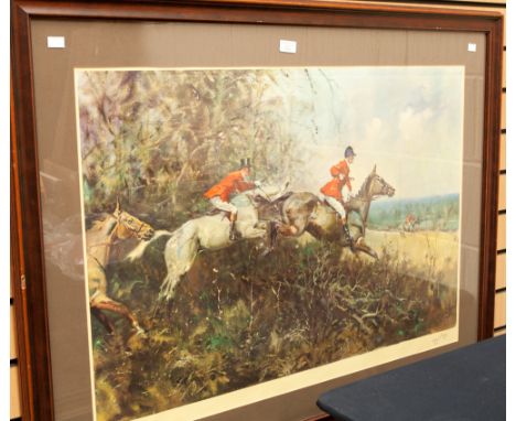 A large framed print, depicting a hunting scene with horse galloping over the hedge, signed lower right, mounted and framed, 