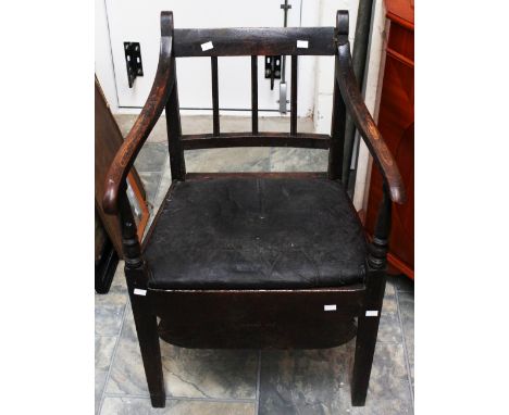 A George III oak commode chair, circa 1800, the later covered seat retaining the original rush beneath, with turned arm suppo