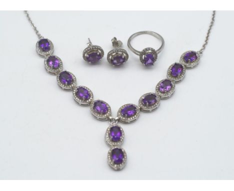 A collection of amethyst and silver jewellery Matching set, includes a halo ring, earrings and a necklace.