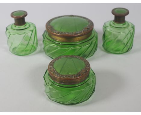 Four art deco green glass toiletry bottles with brass floral and green enamel style tops, height 8cm approx