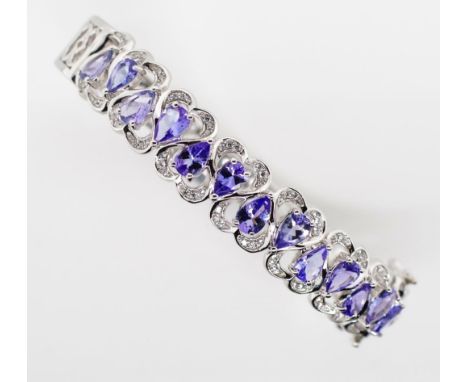 Tanzanite and sterling silver bangle. Hinged bangle with saftey clasp. Approx Set with 13x 6.mm x 3.7mm drop cut tanzanites. 