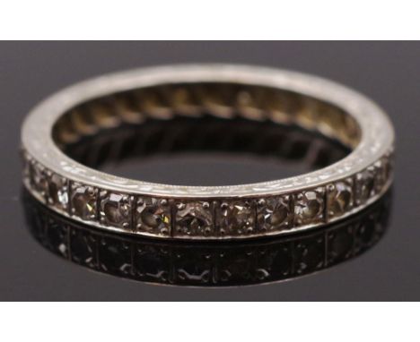 Diamond and white gold eternity ring. Flat shape ring with engraved borders approx 2.4 grams, ring size R. Test as 9ct and pl