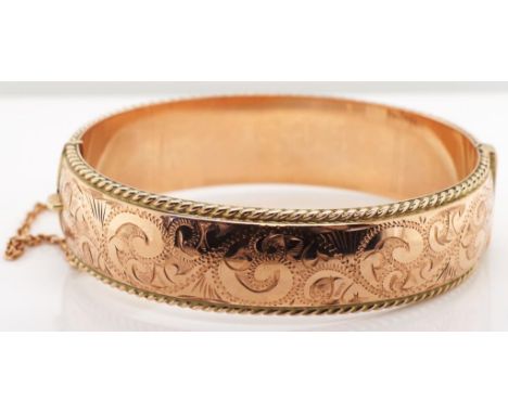 9ct rose gold bangle. Hinged bangle with safety chain and box clasp. Marked 9ct Made in NZ . Approx 33 grams total weight