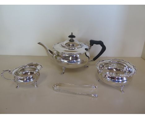 A silver three piece tea service, with associated nips, Sheffield 1911 and 1912, approx total 29 troy oz, some denting to all