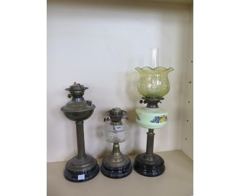 Three oil lamps, one with coloured glass font (font cracked) and green glass shade and two lamp bases 