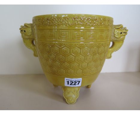 A Chinese ceramic censer with mustard yellow glaze, twin fo dog headed lug handles, raised upon a triform vase, six character